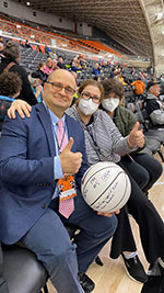 Dr. Eladoumikdachi and his family in the stands at a Princeton basketball game, Dr. Eladoumikdachi is holding a basketball and giving a thumbs up